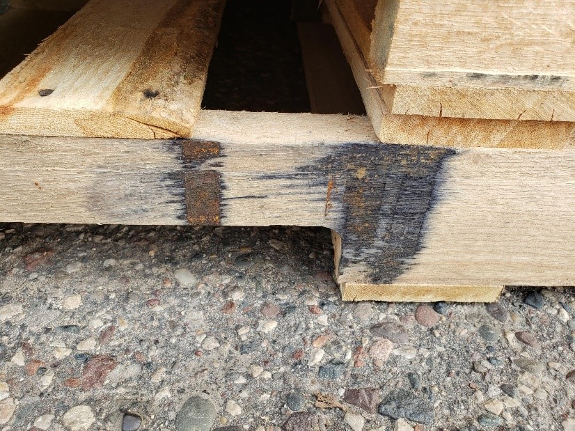 Tannic acid reaction causing dark gray discoloration on pallet wood